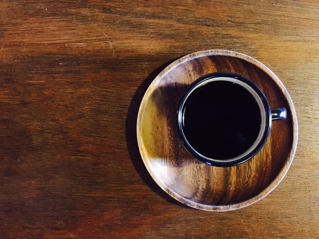 木桌上放著一杯黑咖啡