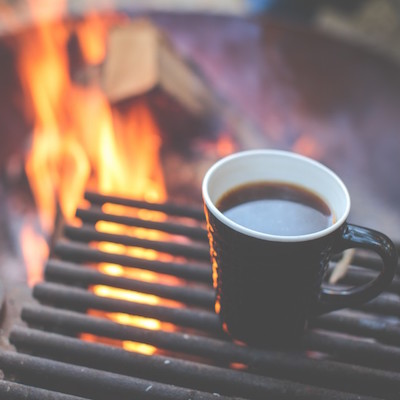 深焙-燒得正旺的柴火旁，鐵架上有一杯黑咖啡